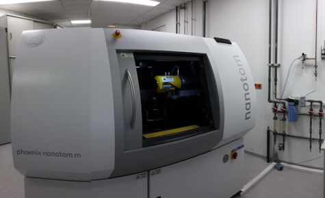 A laboratory equipped with a computerized X-ray tomograph, several computers displaying 3D scans on monitors.