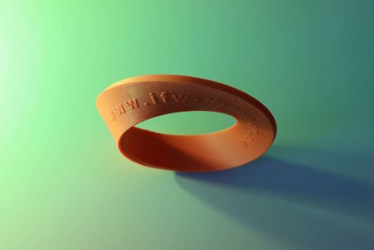 Ein orangefarbener topologischer Ring vor grünem Hintergrund.