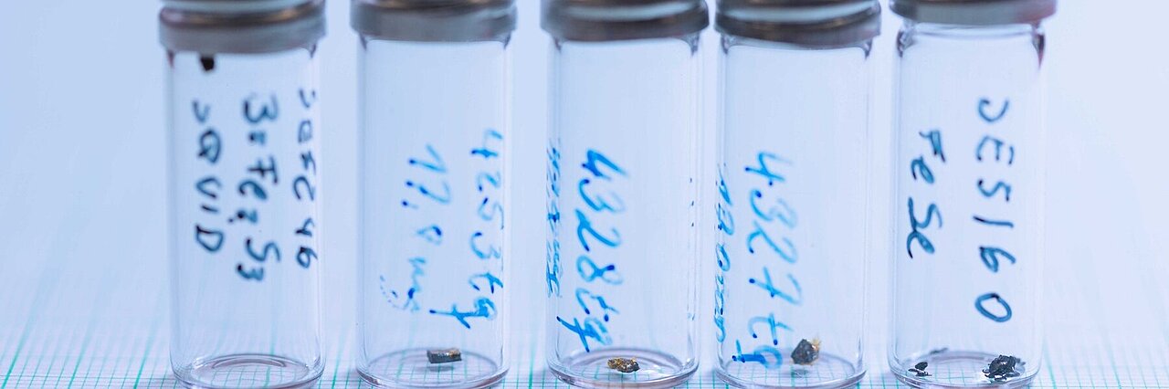 five sample glasses with small single crystals
