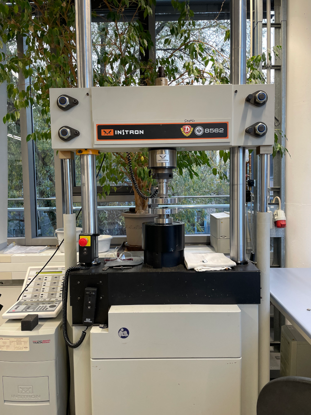 Instron 8562 testing machine in a laboratory room.