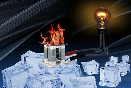 Ein metallenes Konstrukt steht mitten in einer Ansammlung aus Eiswürfeln. Über dem Konstrukt brennt eine Flamme. das Kosntrukt ist mit einem Kabel verbunden, woran eine brennende Glühlampe angeschlossen ist.