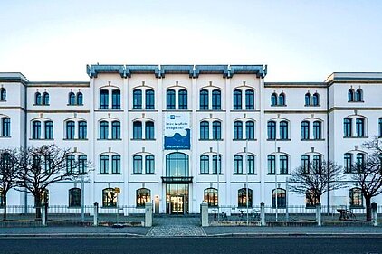 IHK Bildungszentrum Dresden Frontalansicht des historischen mehrstöckigen Gebäudes des IHK Bildungszentrums Dresden mit symmetrischer Fensteranordnung und kahlen Bäumen davor.
