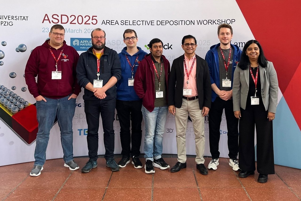 A group of people are standing in front of a backdrop bearing the title of the ASD Workshop 2025 in Leipzig.