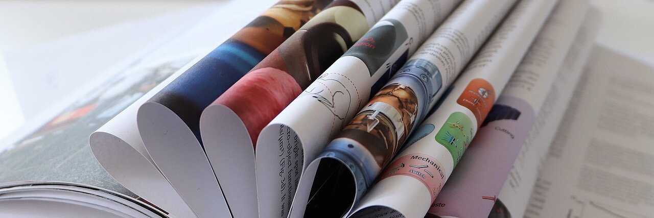 Open report with multiple folded pages on a white table.