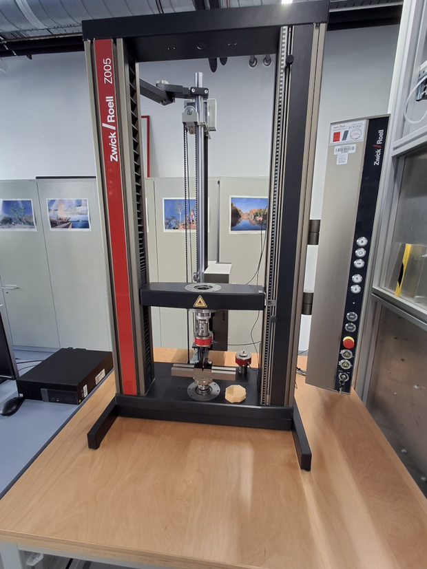 Zwick Roell Z005 testing machine with vertical test area on a wooden table in a laboratory room.