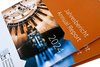 Der Coverumschlag des IFW-Jahresberichtes in der Nahaufnahme. Der Umschlag ist hauptsächlich orange und zeigt auf dem Foto einen wissenschaftlichen Experimentalaufbau..