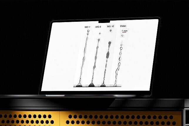 Laptop mit Darstellung verschiedener Flüssigkeitsstrahlen aus Mikrogel-Lösungen und Wasser.