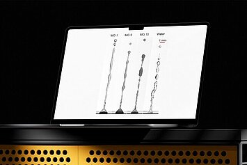 Laptop mit Darstellung verschiedener Flüssigkeitsstrahlen aus Mikrogel-Lösungen und Wasser.