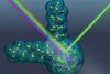 Grün-blaues schematisches Atom-Molekül-Modell. Auf das Zentrum fallen bunte Strahlen. Ein grünlicher Stahl wird am Zentrum im rechten Winkel reflektiert.. 