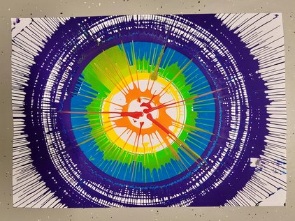 Abstract image with concentric rings of blue, green, yellow, and orange radiating from a central point. One Art Example on pictures that are created at this station.