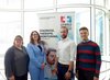 5 Personen stehen vor einem Poster zum Leibniz-Forschungsverbund Gesundheitstechnologie.