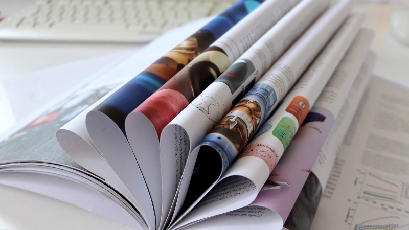 Open report with multiple folded pages on a white table.